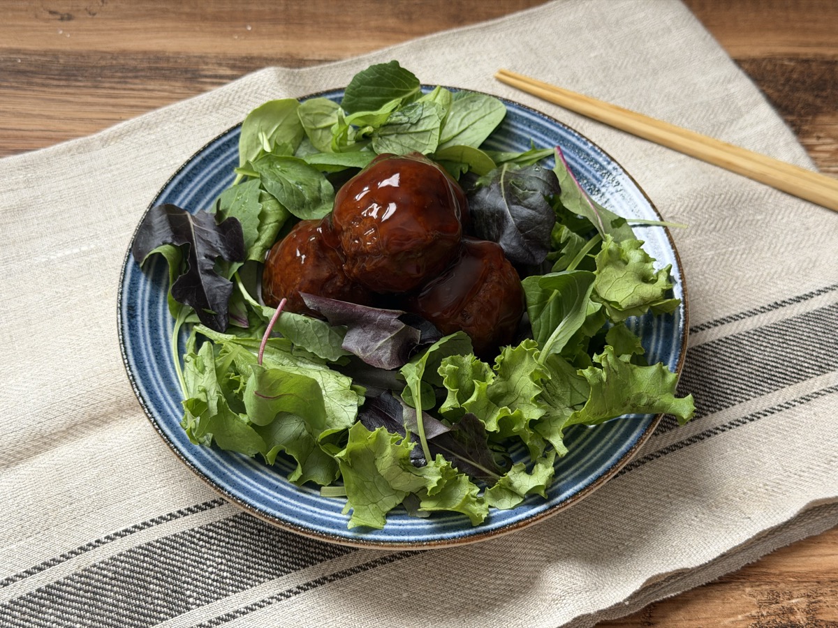 肉団子黒酢あんをベビーリーフに添えて盛り付け